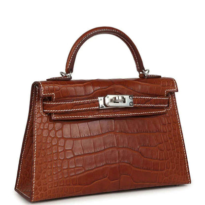 Crocodile leather Kelly Sellier bag with top handle, front lock, and stitched trim