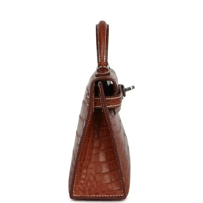 Fauve croc leather Kelly Sellier bag side view with handle and strap attachment