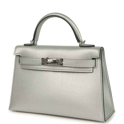 Light gray leather mini handbag with top handle, front turn-lock and side panels