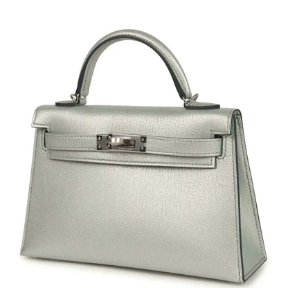 Light gray leather mini handbag with top handle, front turn-lock and side panels