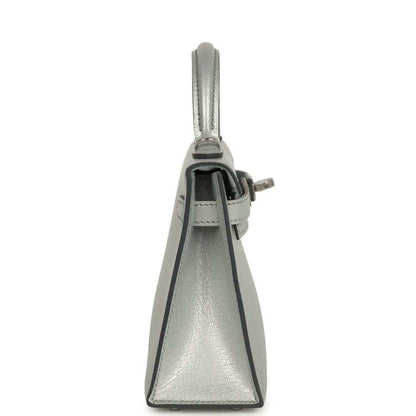 Light gray leather mini handbag, side view with top handle and closure