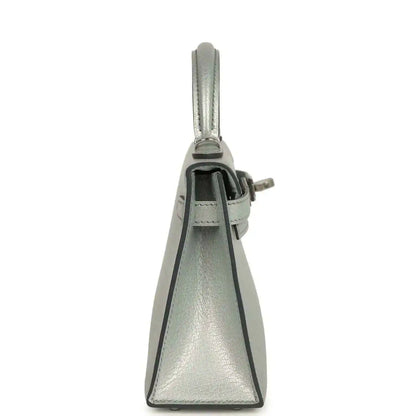 Light gray leather mini handbag, side view with top handle and closure