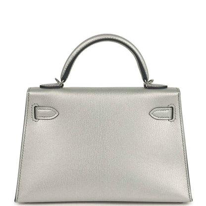 Light gray leather mini handbag with top handle and decorative front strap