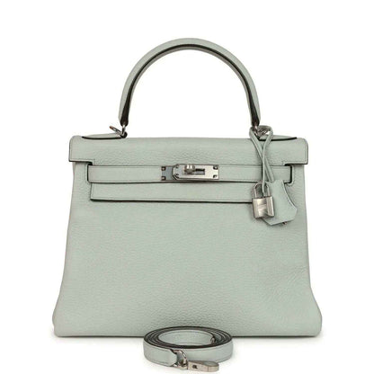 Light blue leather Kelly-style bag with silver-tone clasp, top handle, and wrist strap.