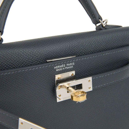 Hermes Kelly Sellier 20 bag close-up of gold-tone front lock on gray-blue leather