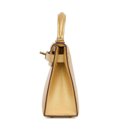Kelly Sellier 20 handbag in gold leather, side view with top handle and strap loop