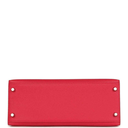 Red leather handbag panel with two metal studs along top edge.