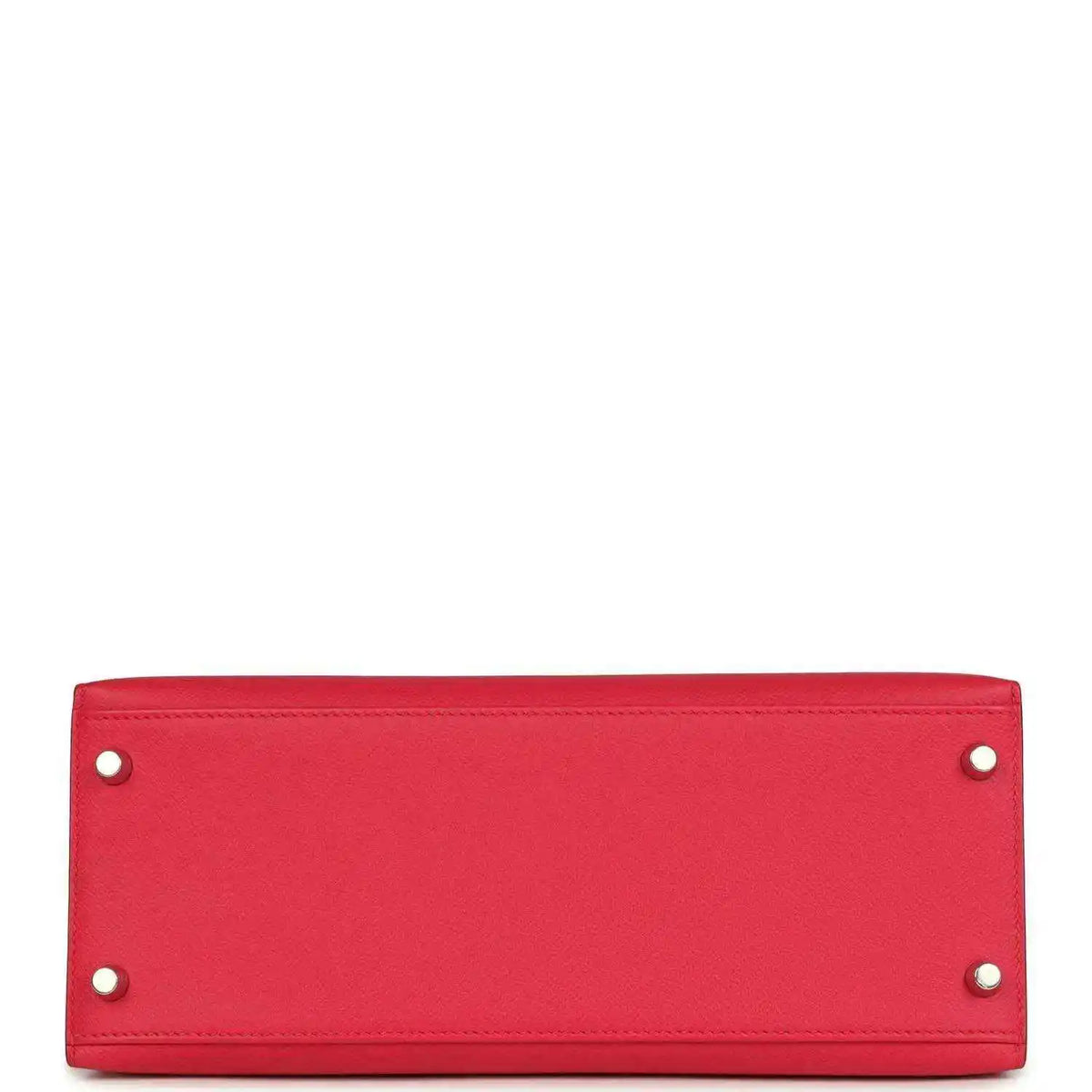 Red leather handbag panel with two metal studs along top edge.