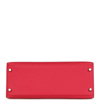 Red leather handbag panel with two metal studs along top edge.