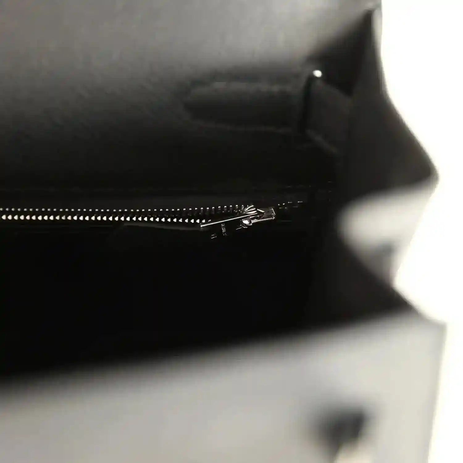 Close-up of interior zipper track along the top edge of the leather handbag