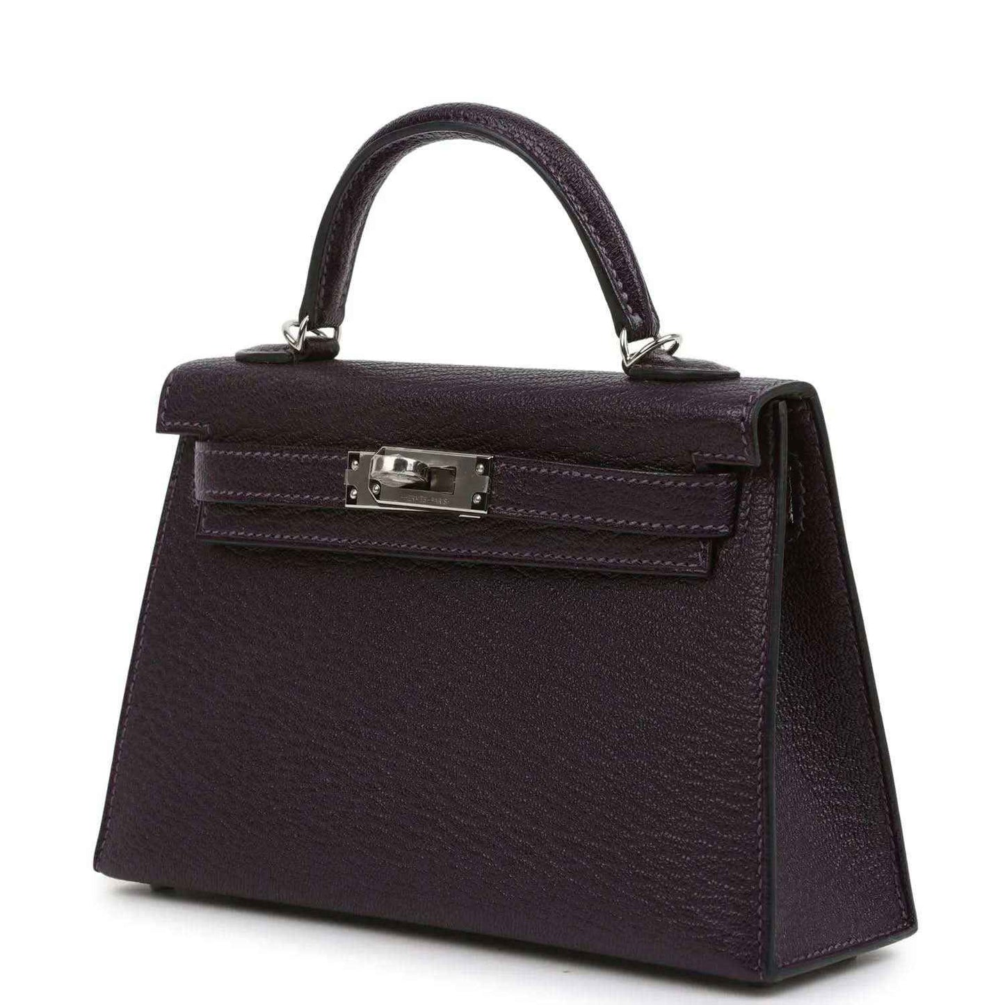 Purple leather handbag with top handle, front flap and metal clasp hardware.