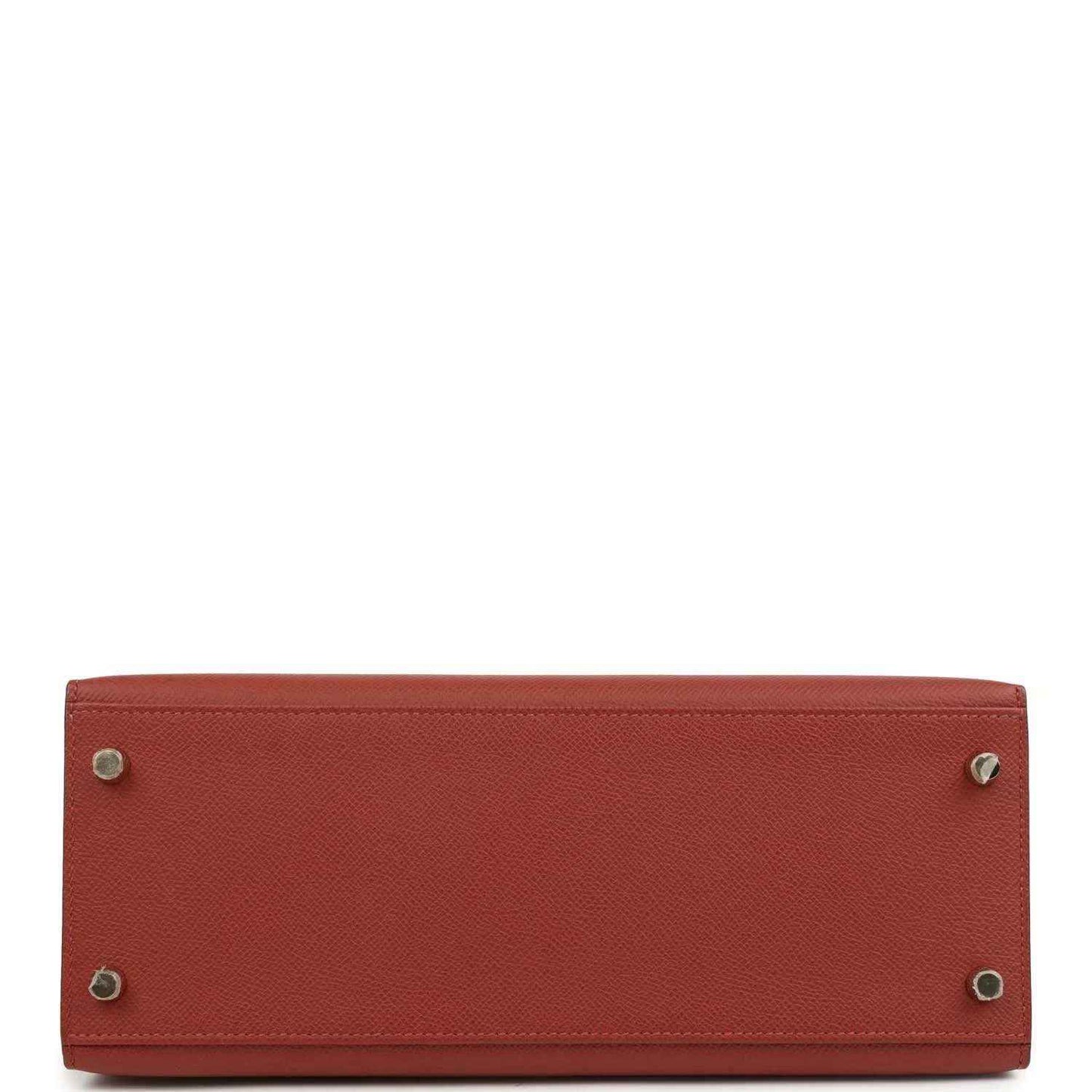 Red leather Kelly handbag bottom with metal feet and stitched edges