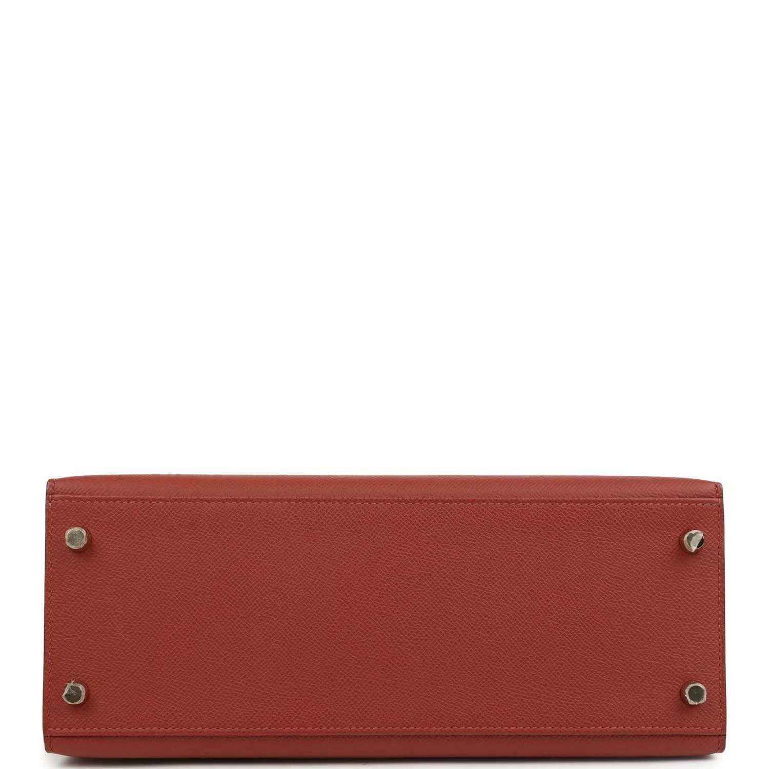 Red leather Kelly handbag bottom with metal feet and stitched edges