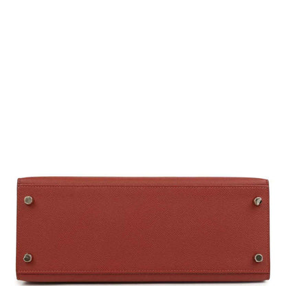 Red leather Kelly handbag bottom with metal feet and stitched edges