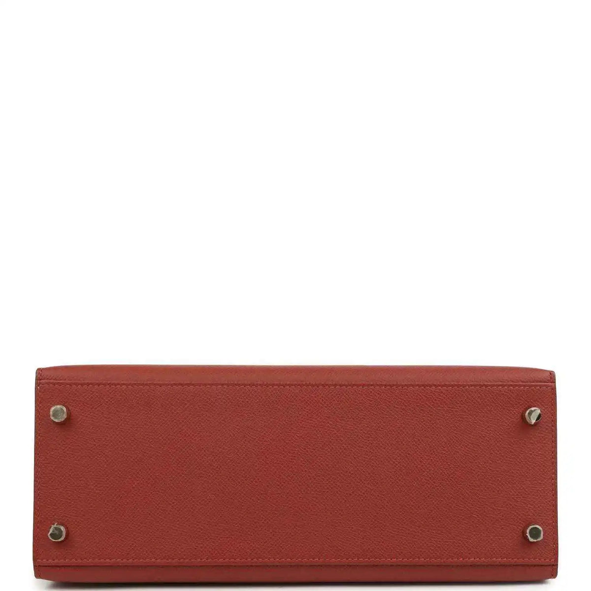 Red leather Kelly handbag bottom with metal feet and stitched edges