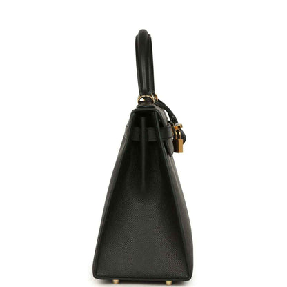 Black leather handbag side view with gold-tone hardware and top handle