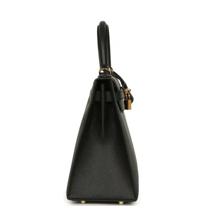 Black leather handbag side view with gold-tone hardware and top handle