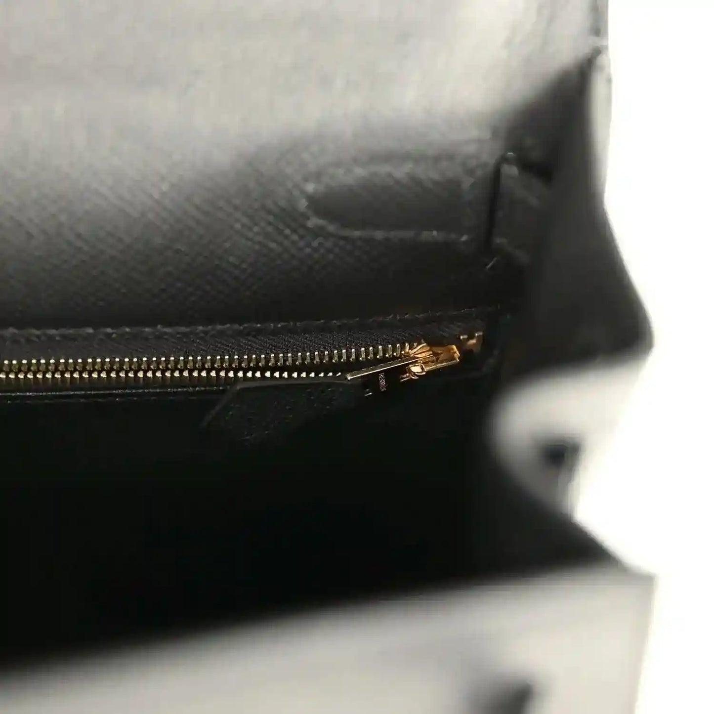 Black leather interior with gold-tone zipper and stitched lining