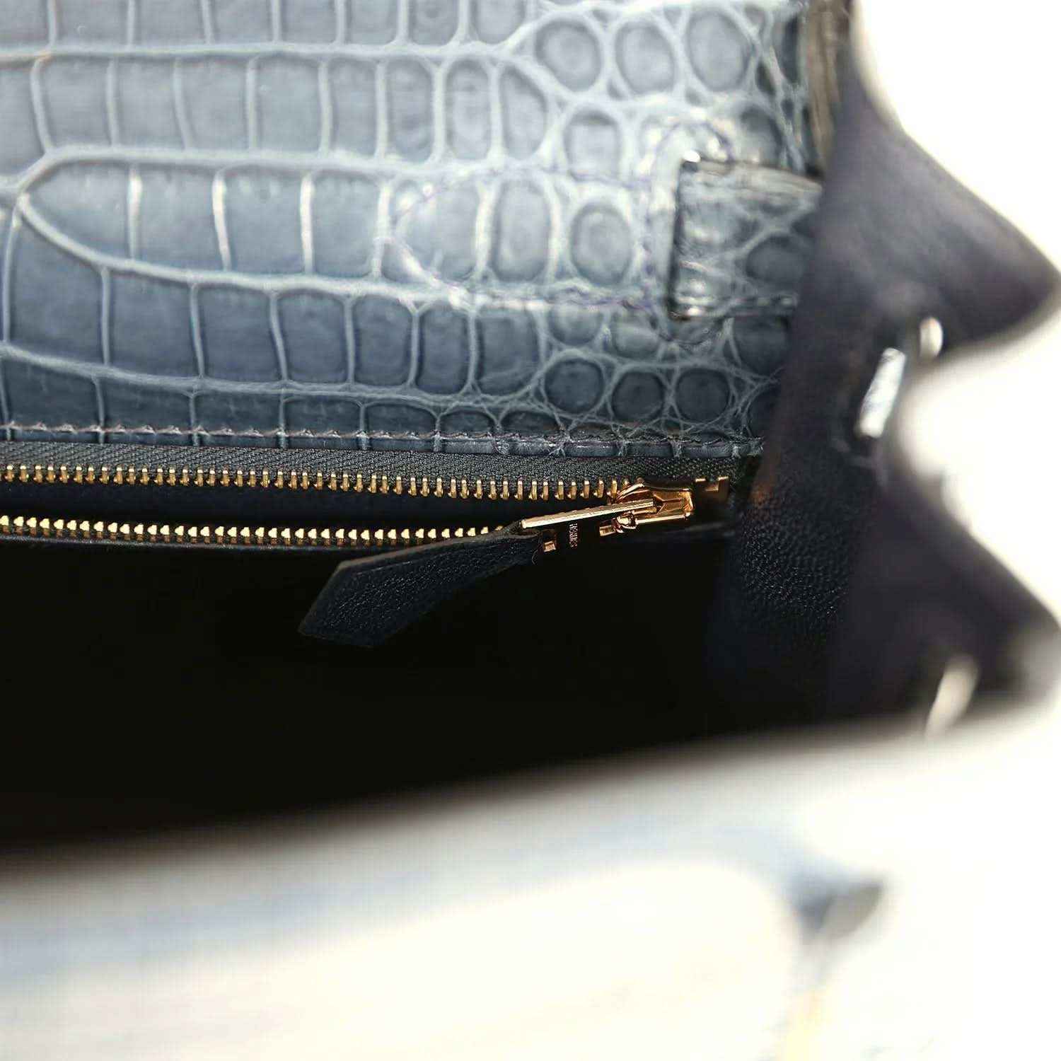 Hermès Kelly Retourne 28 bag close-up of zipped pocket, gold zipper, dark blue croc