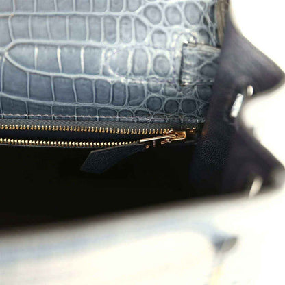 Hermès Kelly Retourne 28 bag close-up of zipped pocket, gold zipper, dark blue croc