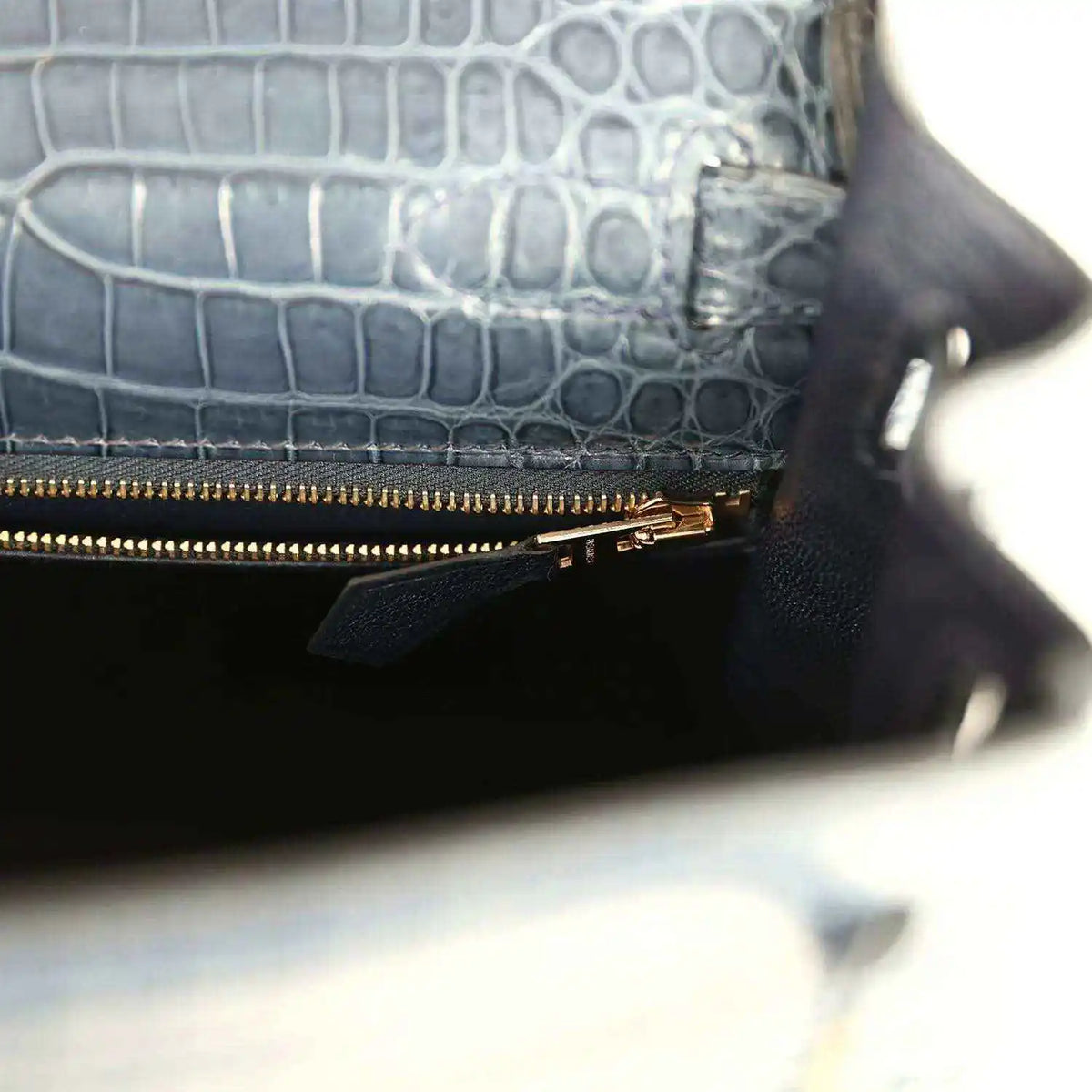 Hermès Kelly Retourne 28 bag close-up of zipped pocket, gold zipper, dark blue croc