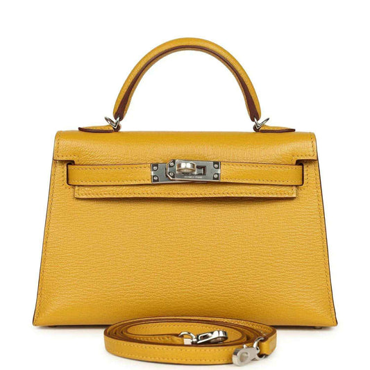 Yellow leather top-handle handbag with front clasp and attached shoulder strap, silver hardware