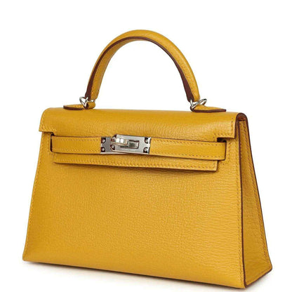 Yellow leather Kelly-style handbag with front flap clasp and top handles, silver hardware