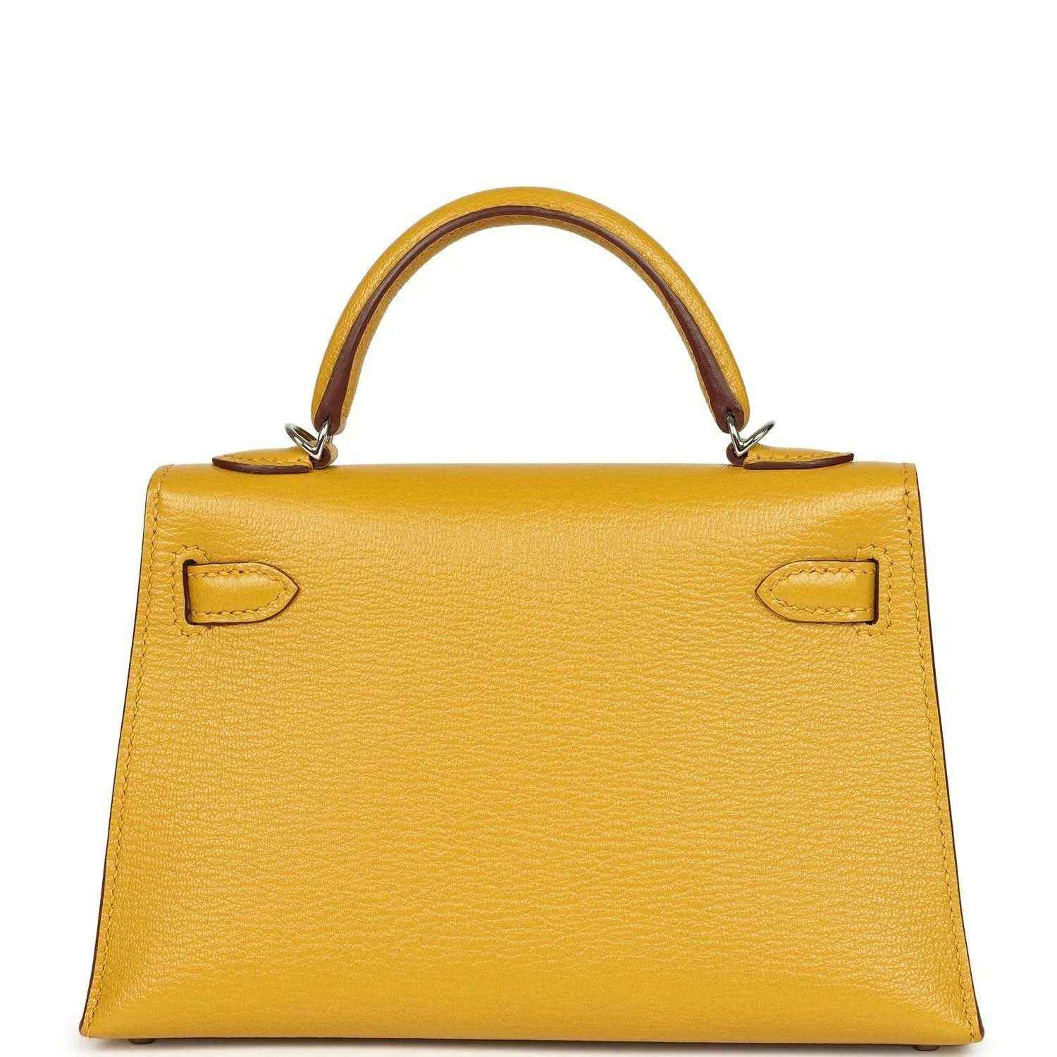 Yellow leather handbag front with curved top handles and symmetrical flap locks, silver-tone hardware