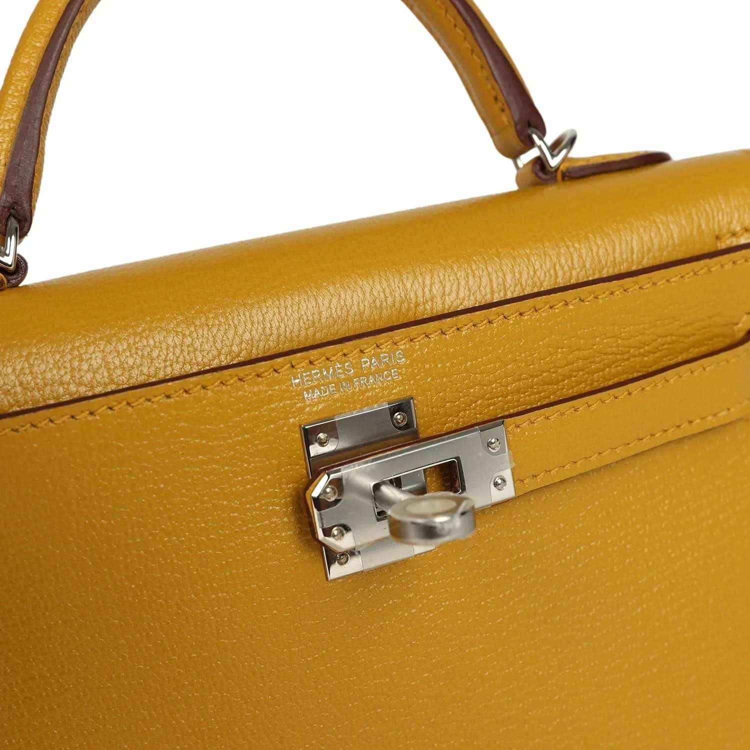 Yellow leather handbag close-up of front clasp with silver-tone hardware