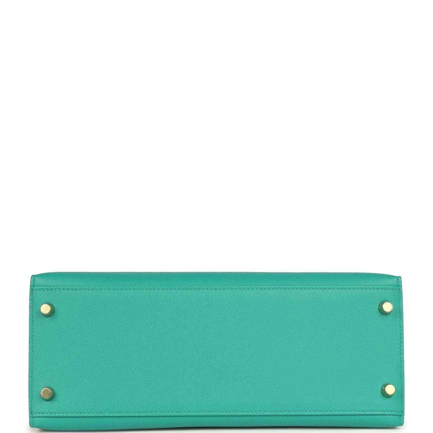 Green leather Kelly-style handbag bottom panel with metal feet and rivets.