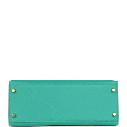 Green leather Kelly-style handbag bottom panel with metal feet and rivets.