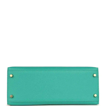 Green leather Kelly-style handbag bottom panel with metal feet and rivets.