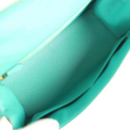 Green leather handbag interior panel with smooth lining and visible stitching seams.