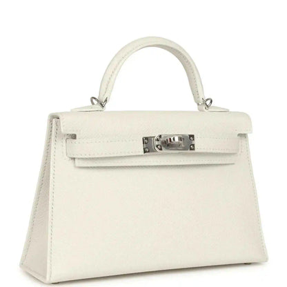 White mini Kelly-style handbag with top handles and front flap with metal clasp