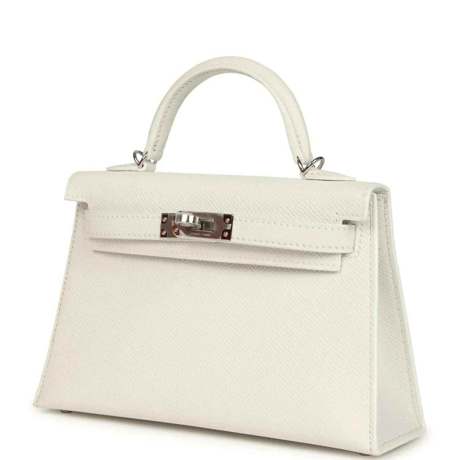 White mini Kelly-style handbag angled view with front flap and metal clasp