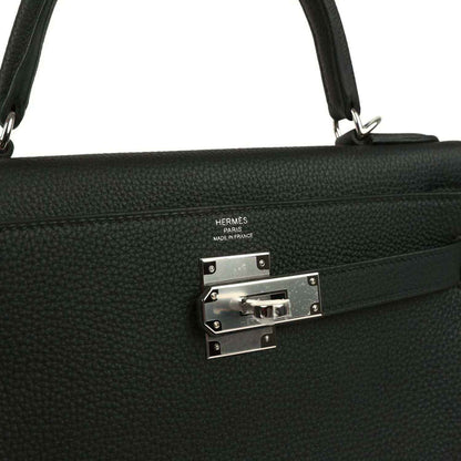 Metal clasp plate with HERMES stamp on black Togo leather Kelly bag
