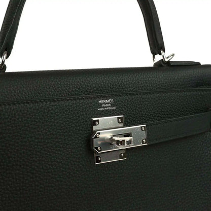 Metal clasp plate with HERMES stamp on black Togo leather Kelly bag