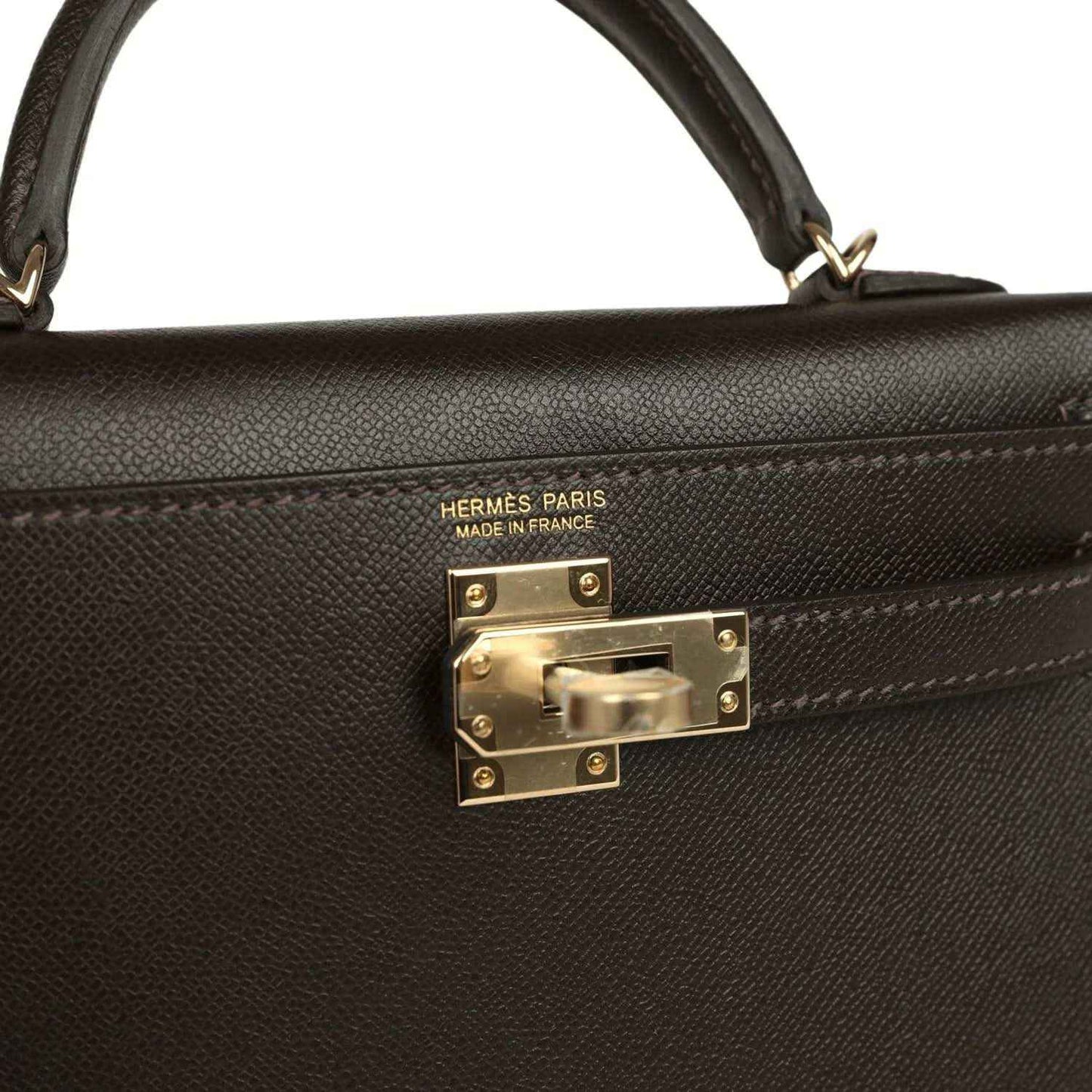 Hermes Paris on dark leather mini bag with gold-tone turn-lock clasp front