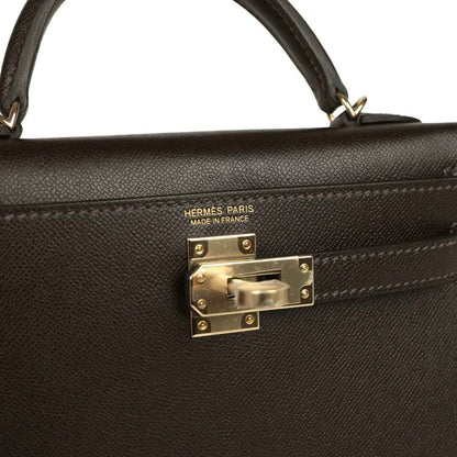 Hermes Paris on dark leather mini bag with gold-tone turn-lock clasp front