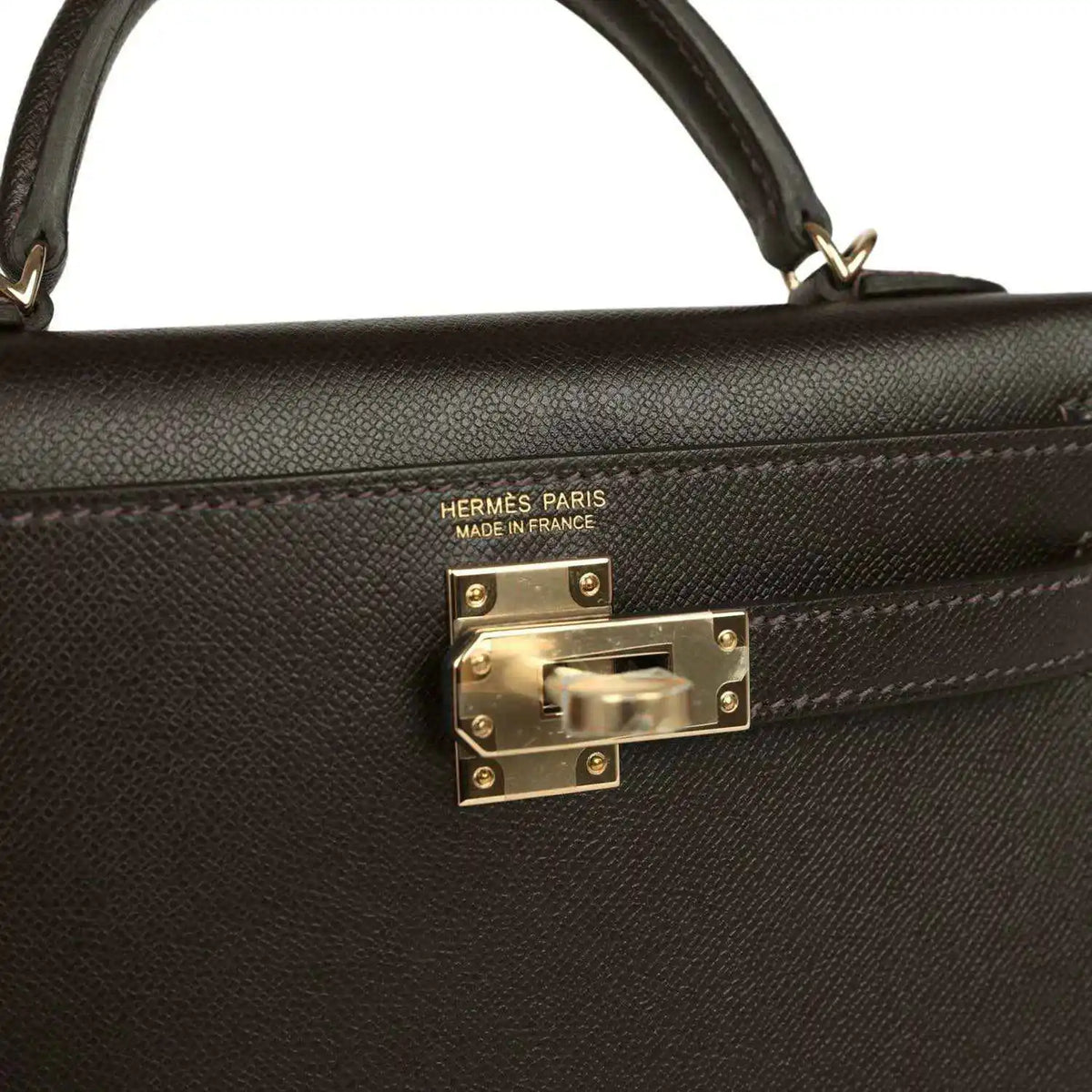 Hermes Paris on dark leather mini bag with gold-tone turn-lock clasp front