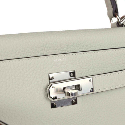 Hermes Kelly Retourne 28 bag close-up of palladium-tone turnlock clasp on the flap