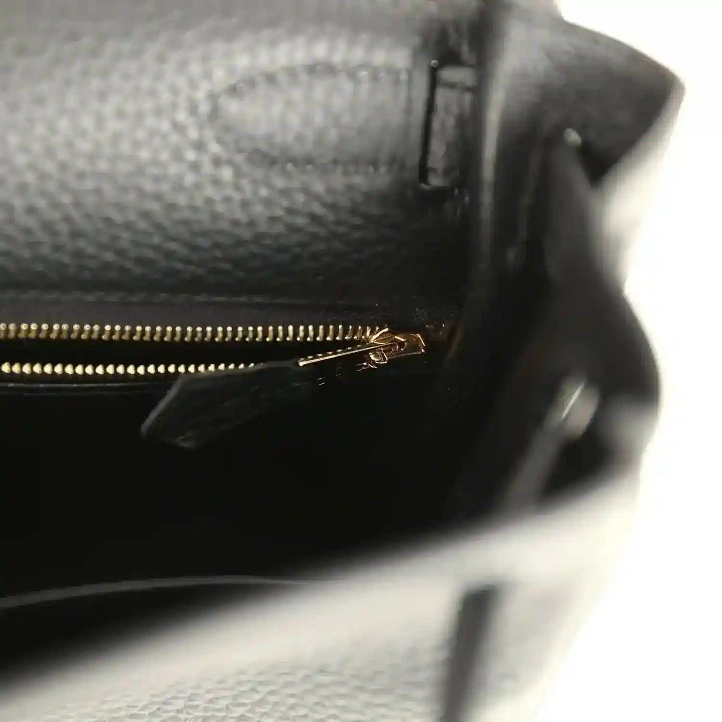 Hermes Kelly Retourne 28 black leather close-up with gold-tone zipper and interior pocket