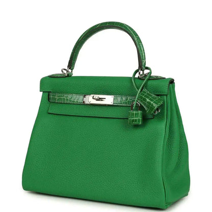 Green leather handbag with front flap, croc-pattern band, and hanging strap charm