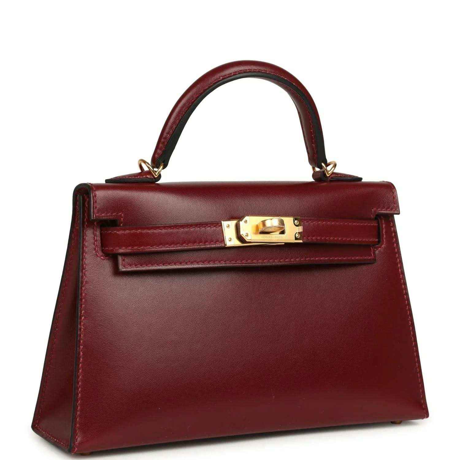 Red leather handbag with top handle and gold front lock hardware.