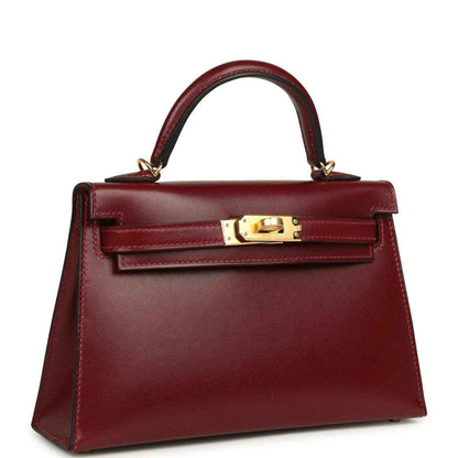 Red leather handbag with top handle and gold front lock hardware.