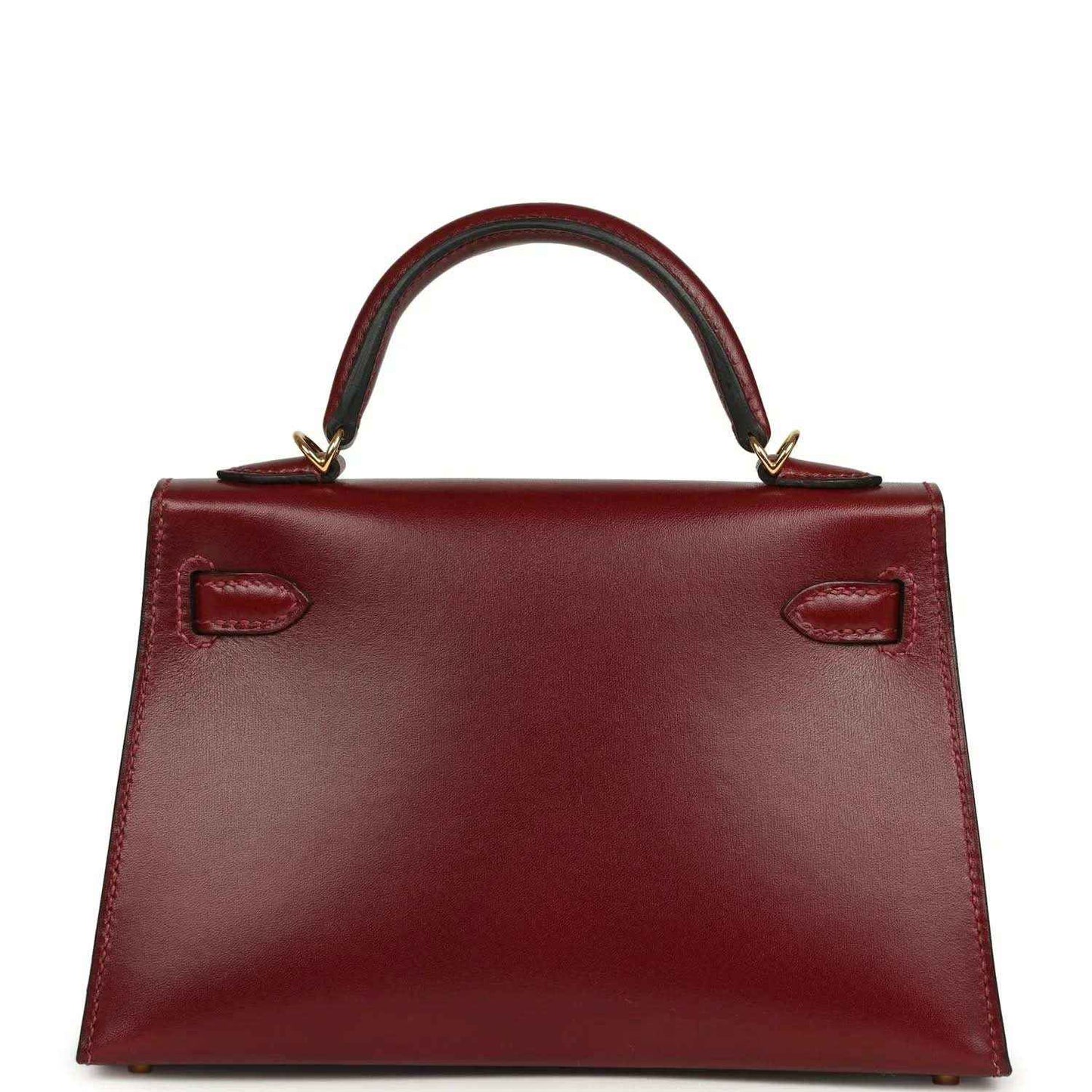 Red leather handbag with structured base and two recessed handle-side details.