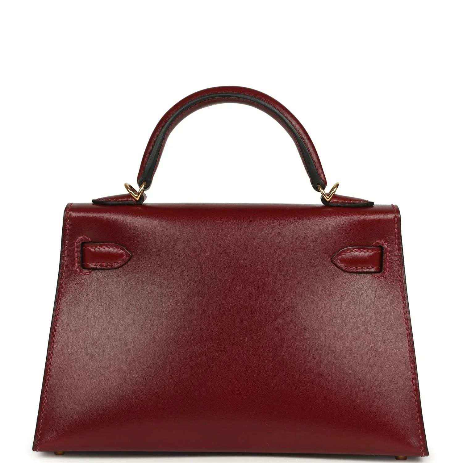 Red leather handbag with structured base and two recessed handle-side details.