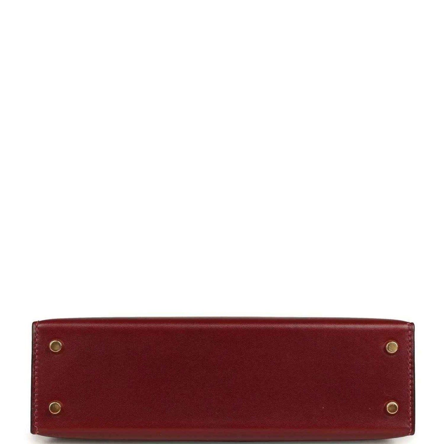 Red leather handbag back panel with four gold-toned rivets.