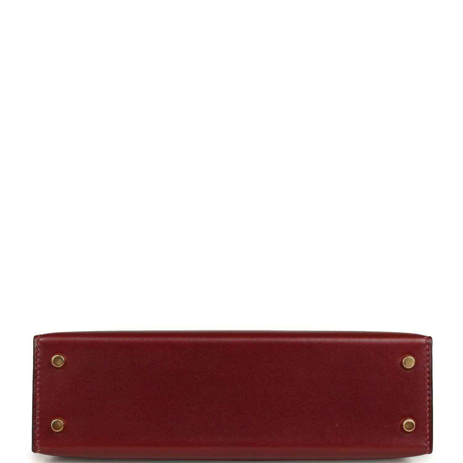 Red leather handbag back panel with four gold-toned rivets.