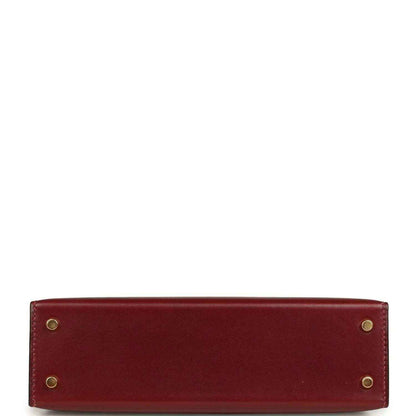 Red leather handbag back panel with four gold-toned rivets.